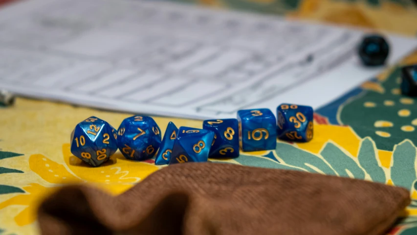 some blue dices and a brown cloth on a table