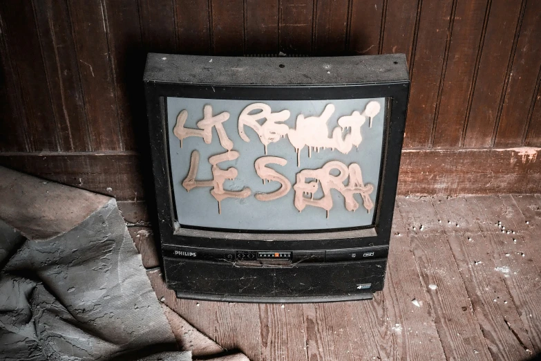 an old black tv set with graffiti on it