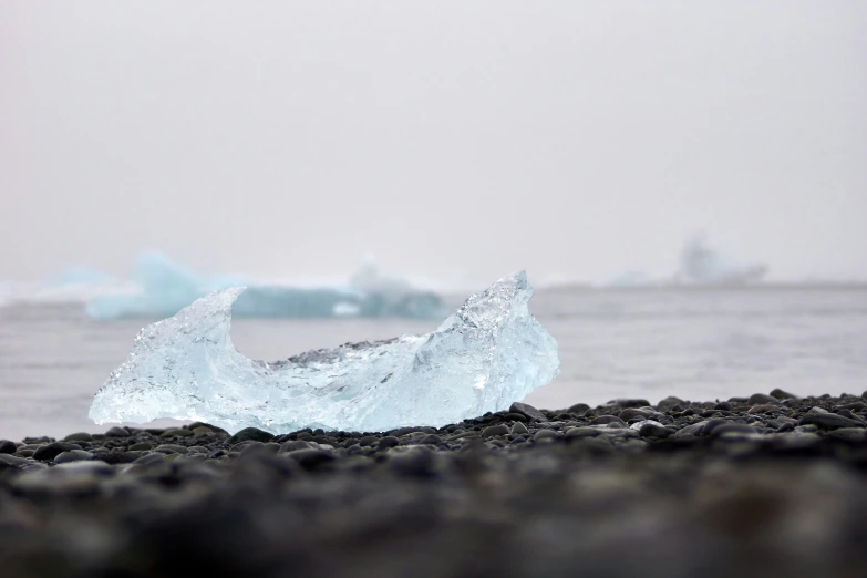 small iceberg floating on a rock shore near the ocean