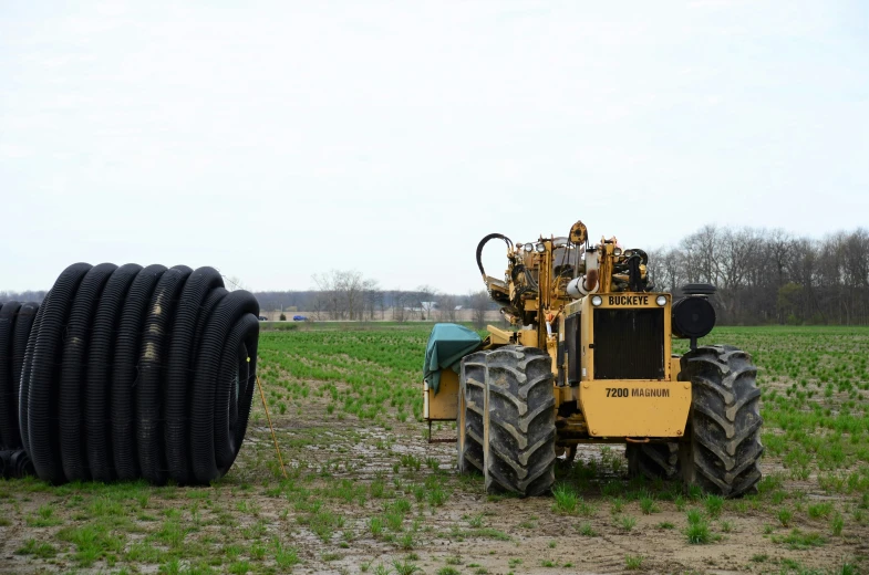 a tractor parked next to tires in the grass