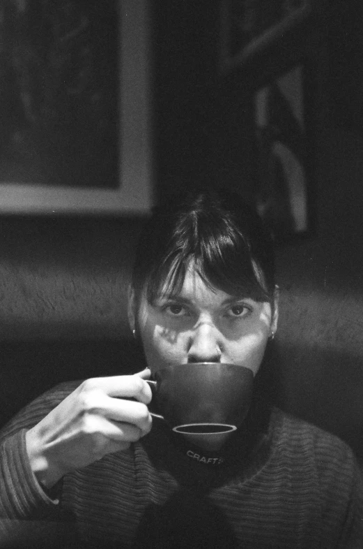 man in black sweater drinking out of a coffee cup