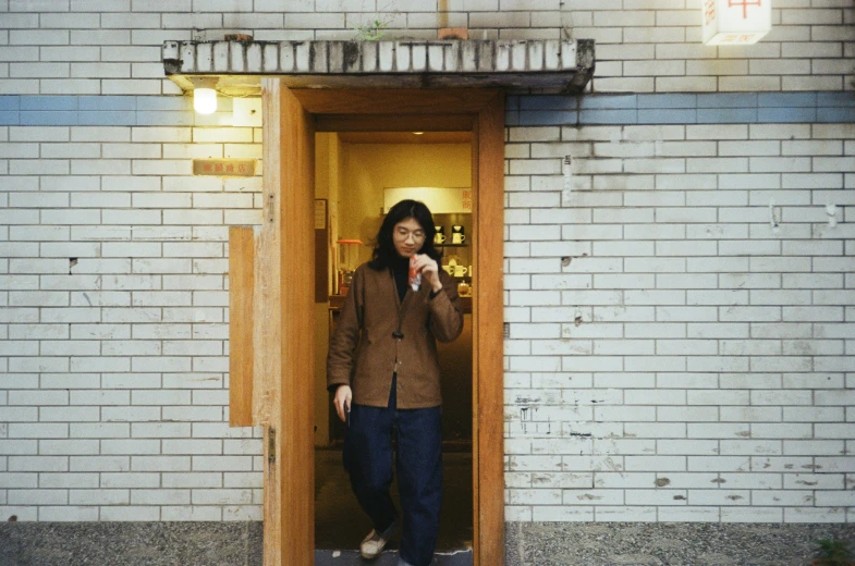 a woman with a cell phone standing in a doorway