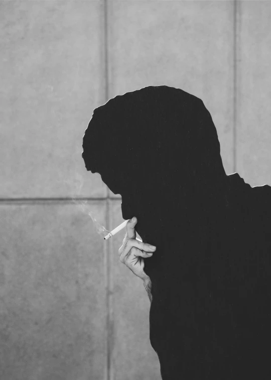 a woman in a black hood holding a cigarette