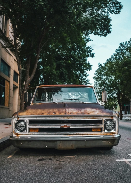 an old truck is parked on the side of a road