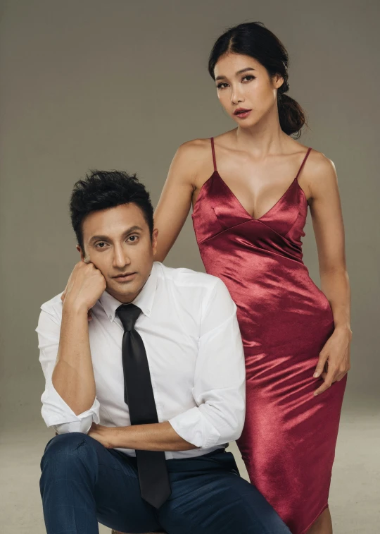 a woman wearing a red dress next to a man in a white shirt