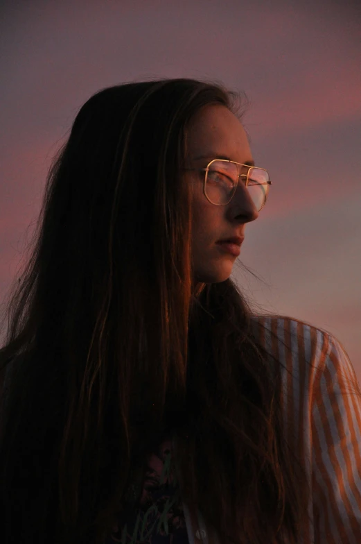 woman with long hair and glasses staring straight ahead