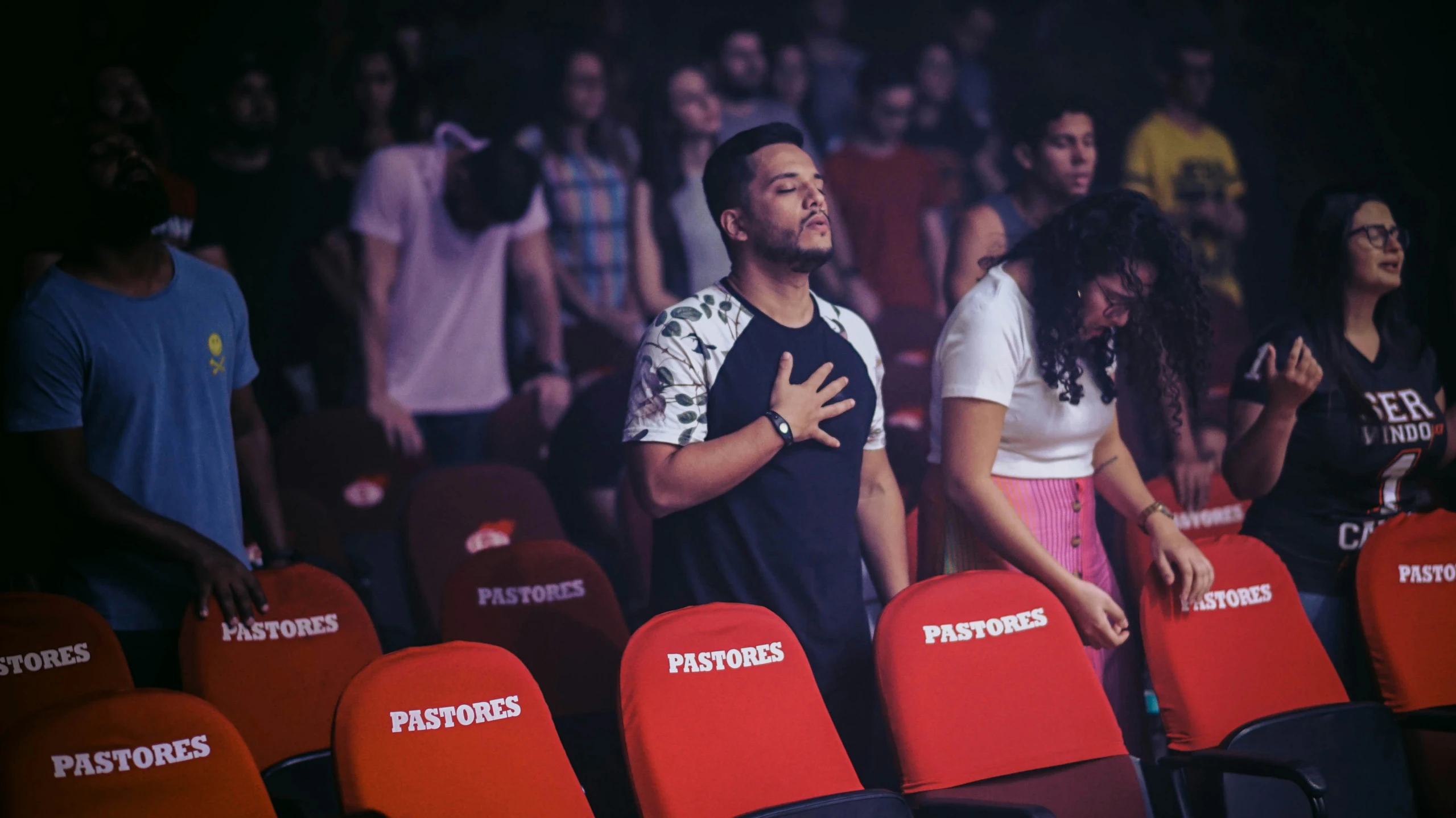 man standing next to a couple of chairs at a basketball game