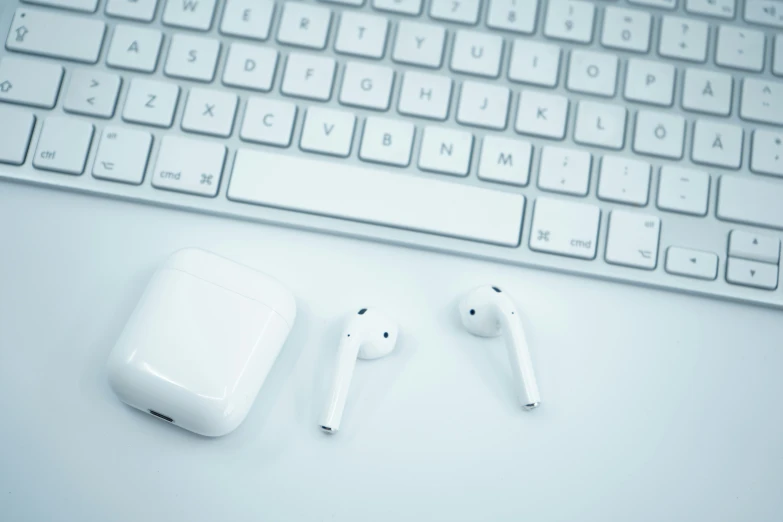 a close up of two ear buds and a keyboard