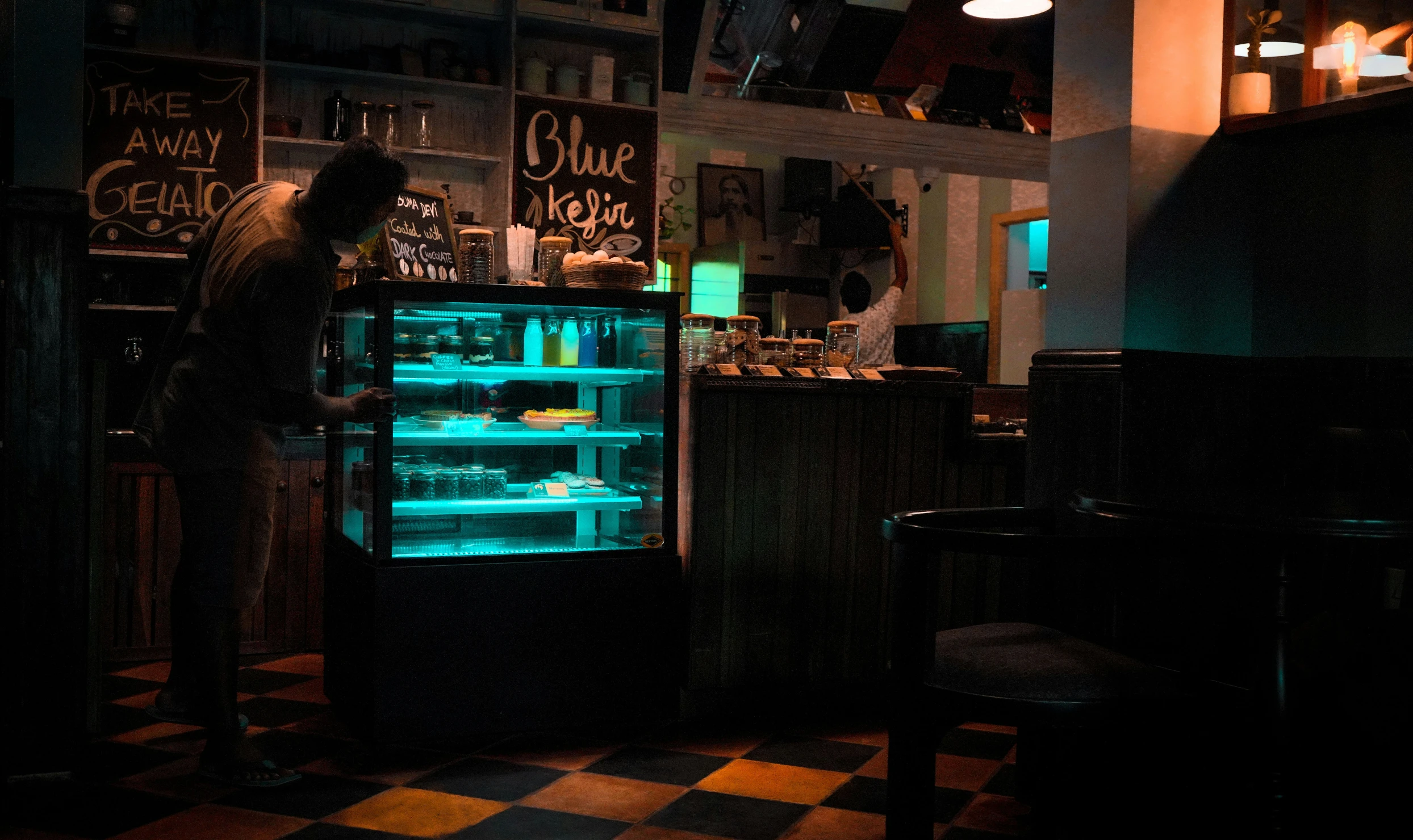 a refrigeration freezer in a dark room with an image of people standing in the window