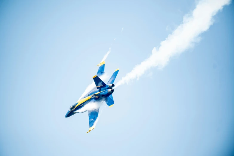 an airplane flying in the blue sky with smoke coming out of it's side