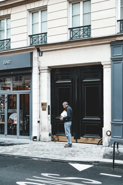 the man is waiting outside the building to purchase some food