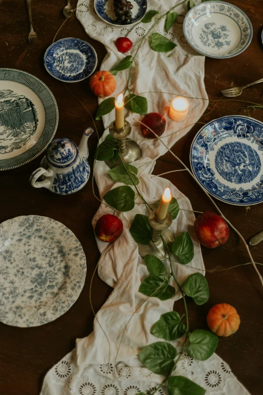 the table is set with dishes and fruit for dinner