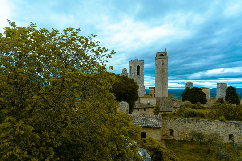 a castle and towers, a clock tower and a lot of trees