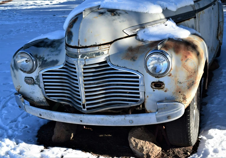 an old car in snow, front end view