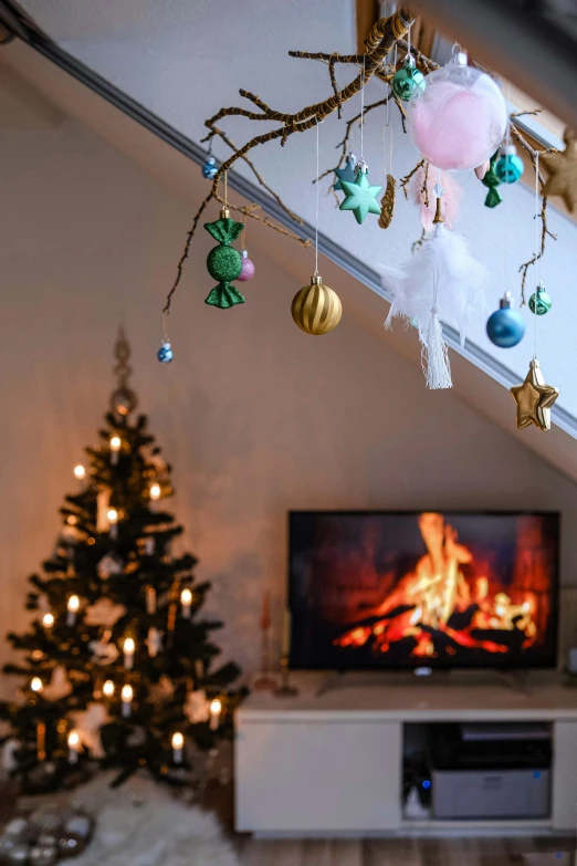 a tree hanging over a television next to a fireplace