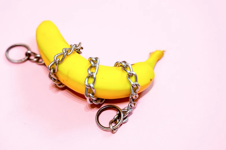 a banana wrapped in chains, with a keyring attached to it