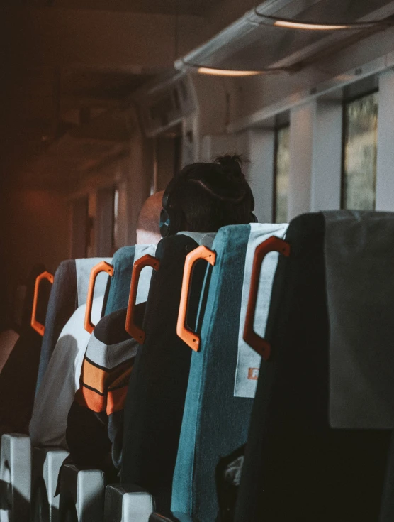 rows of seats with folded clothing attached to them