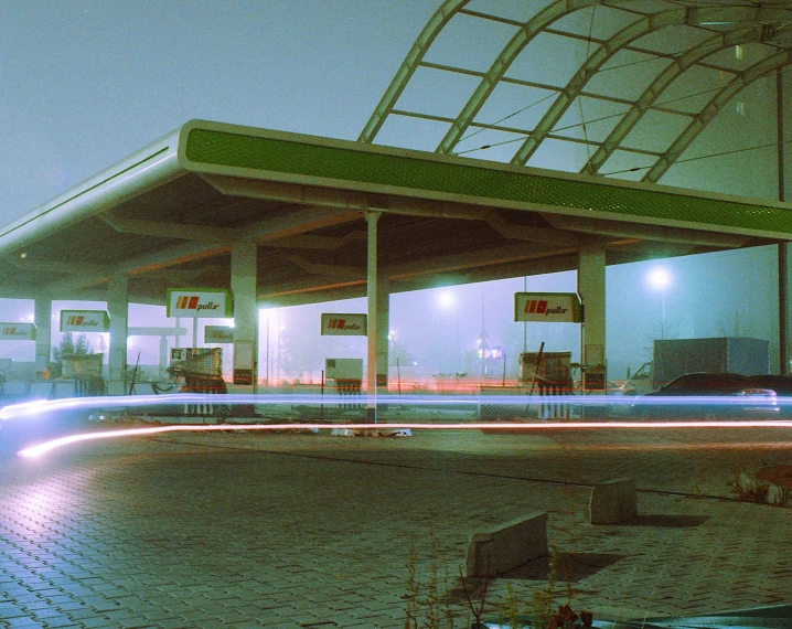 a gas station with a few cars traveling by