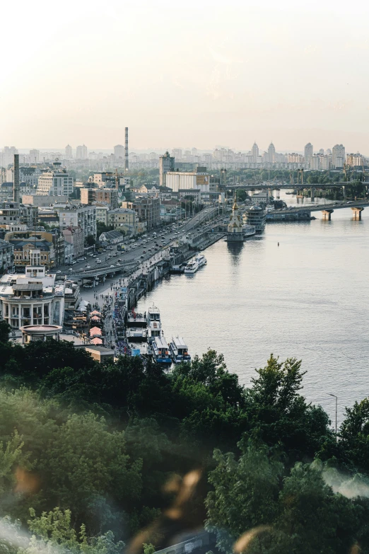 the skyline is visible from a hillside next to a river