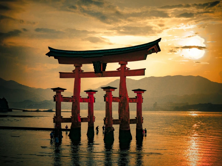 a sunset with some water and a shrine on top