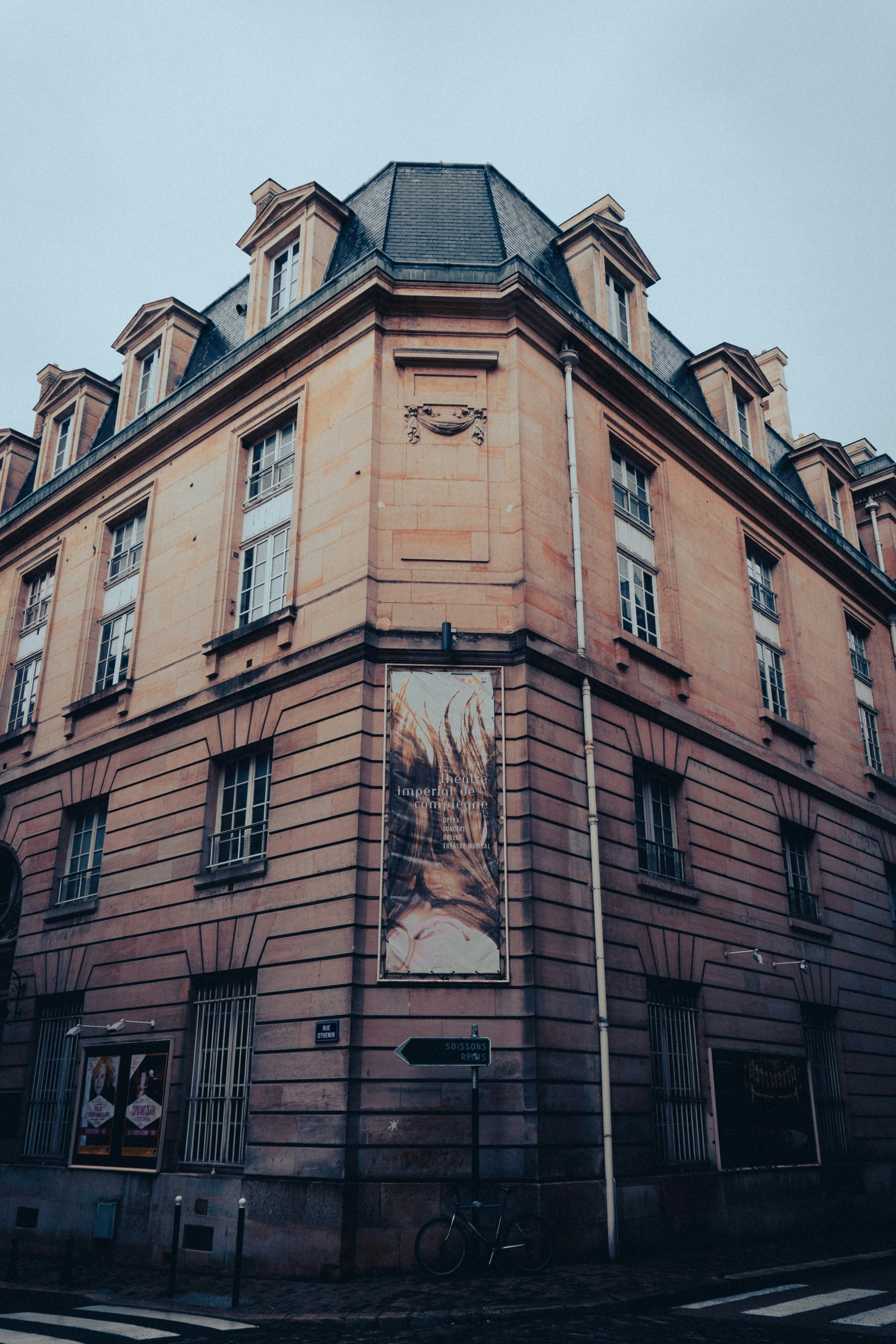 an old brown building with two storys and a black roof