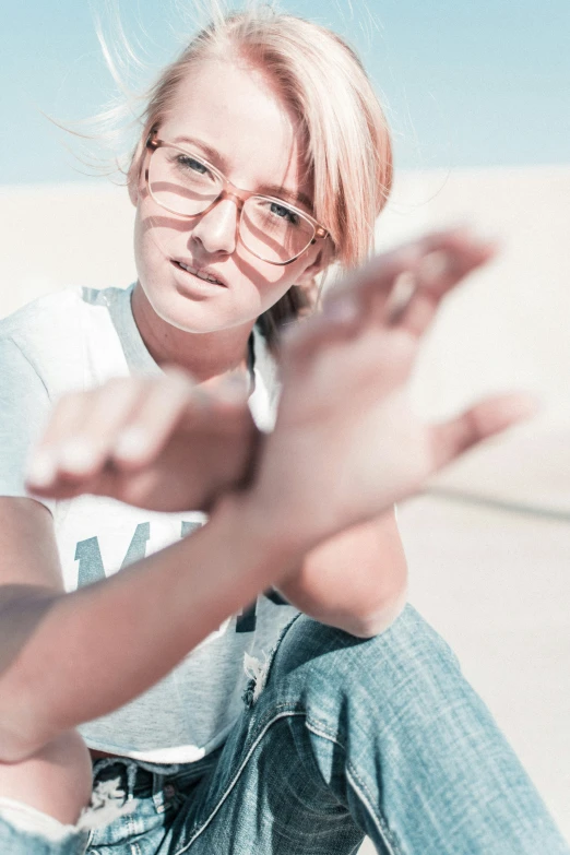 a woman with glasses posing on the beach