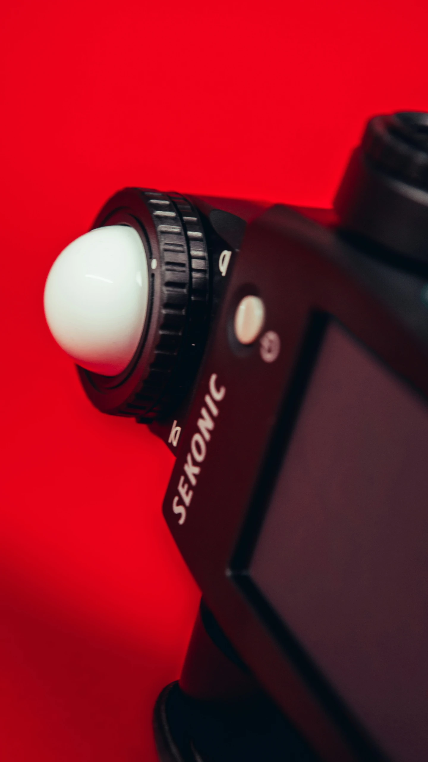 a camera on a red surface, with a black and white lens