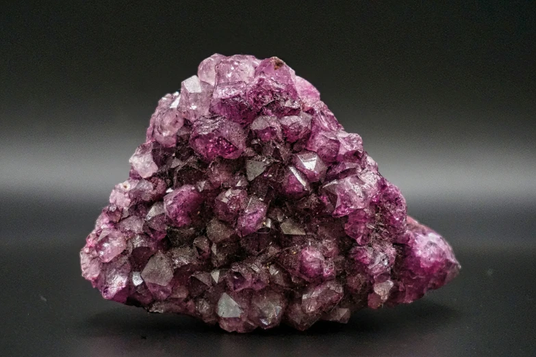 some purple crystals are laying on a black table