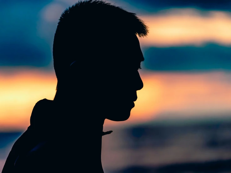 man in silhouette with ocean in the background