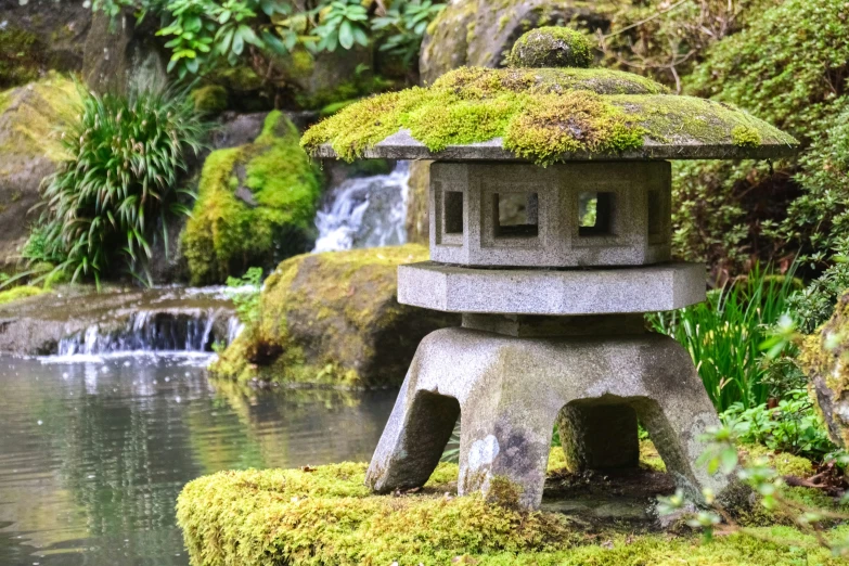 the top of a rock lantern has moss on it