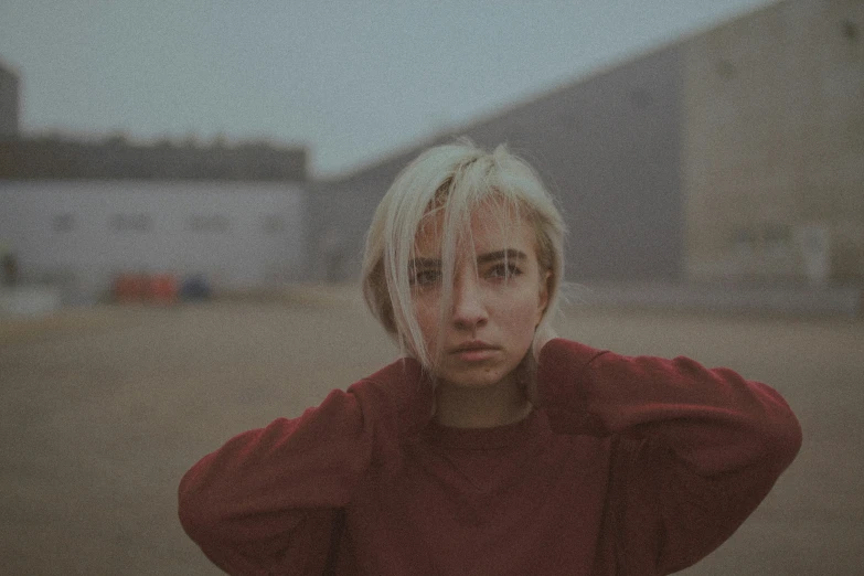 a woman with blonde hair wearing red is looking to her left