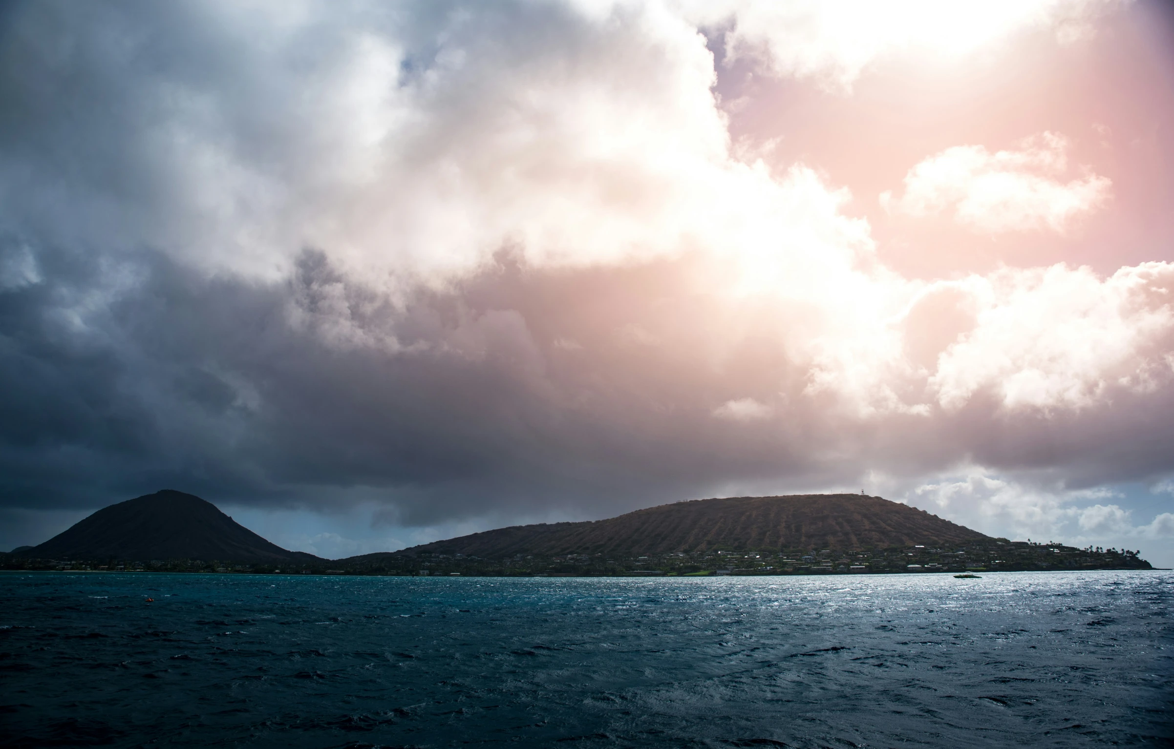 an island is in the distance near some clouds