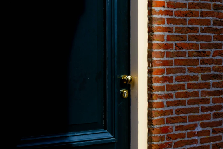 this is an image of the black door and side of a brick building