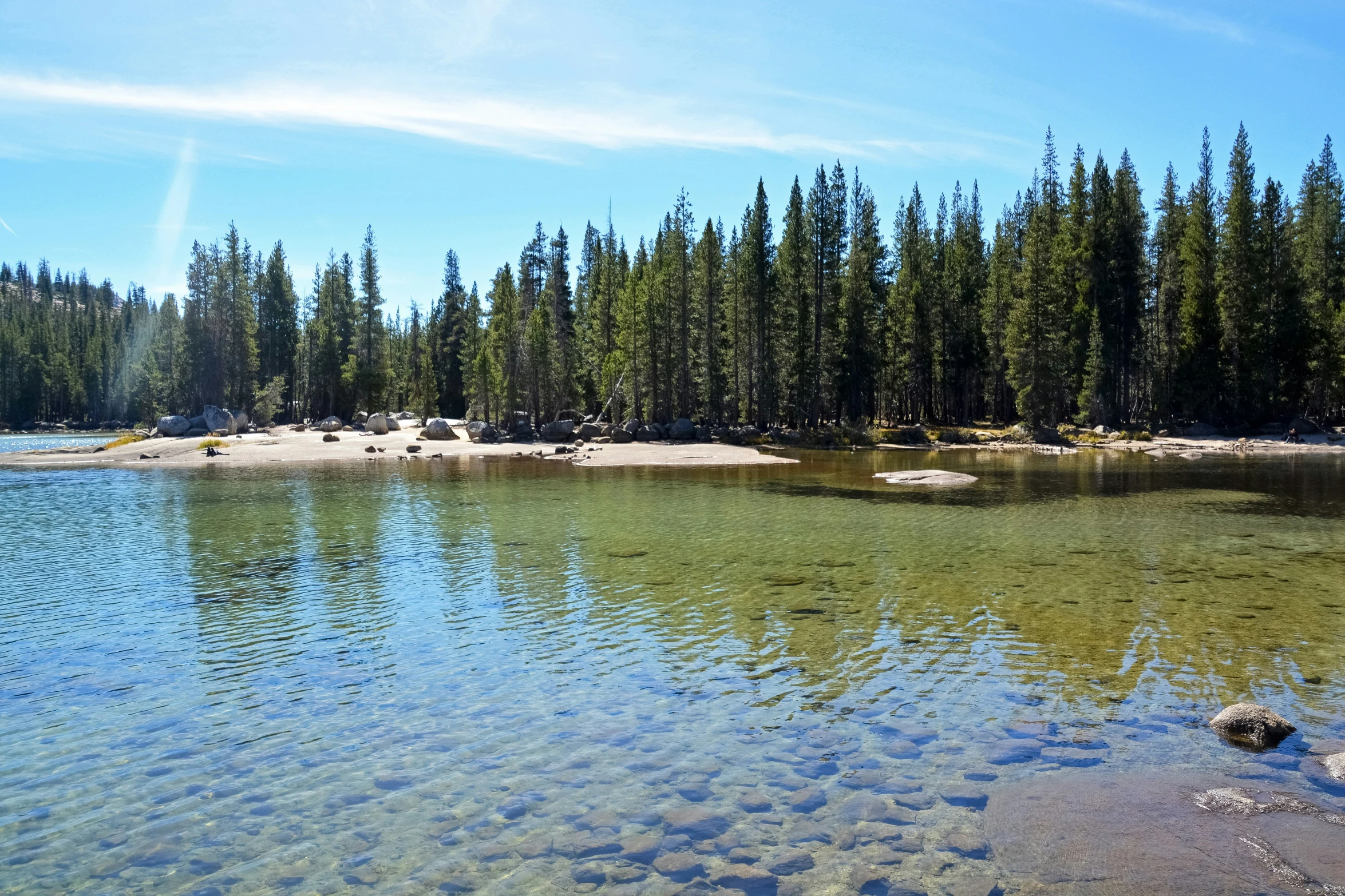 a lake surrounded by trees and sand