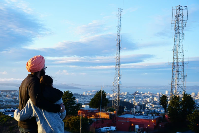 a couple is in front of a large satellite mast