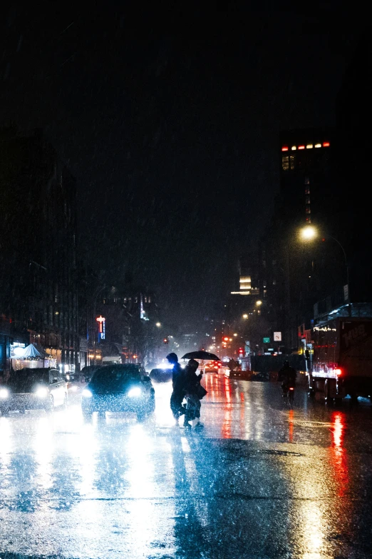 night time picture of cars driving on a wet road