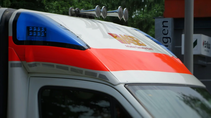 an ambulance parked next to a street sign with tree's in the background