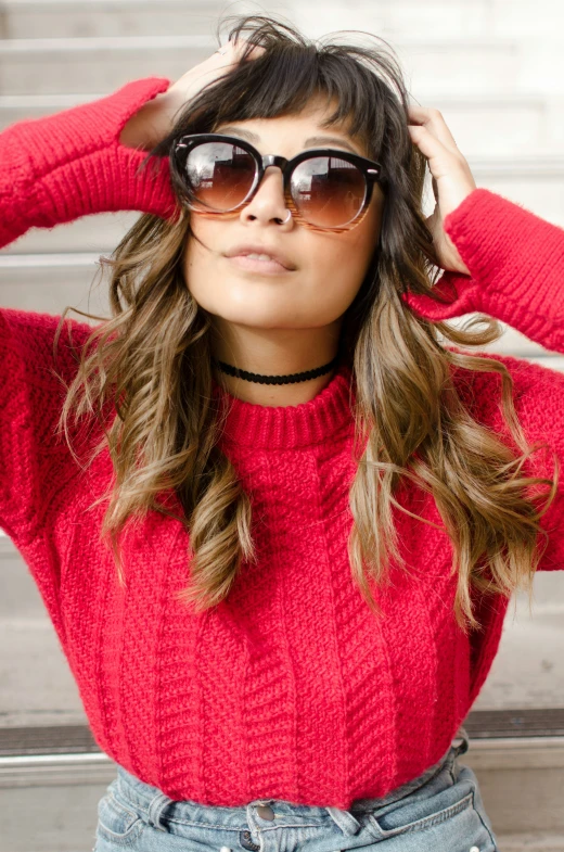 a young woman with sunglasses on her head stands in front of stairs