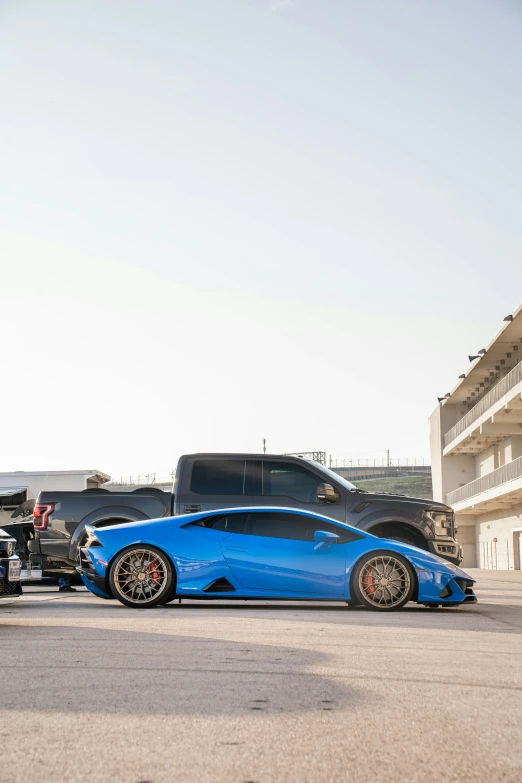 two cars in parking lot, one on a black and the other blue