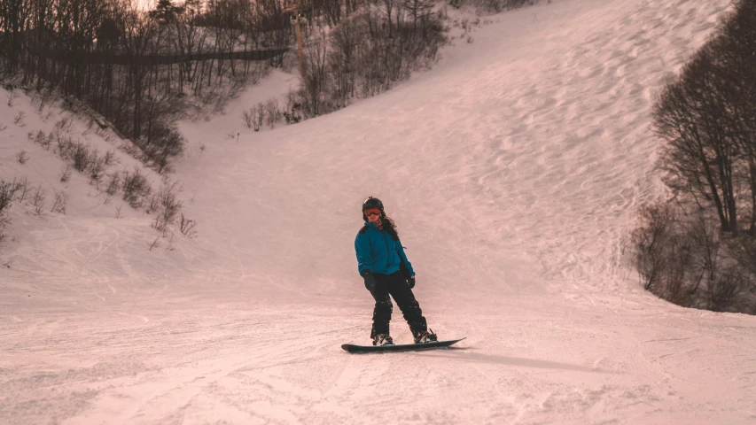 a man riding on top of a snowboard down a hill