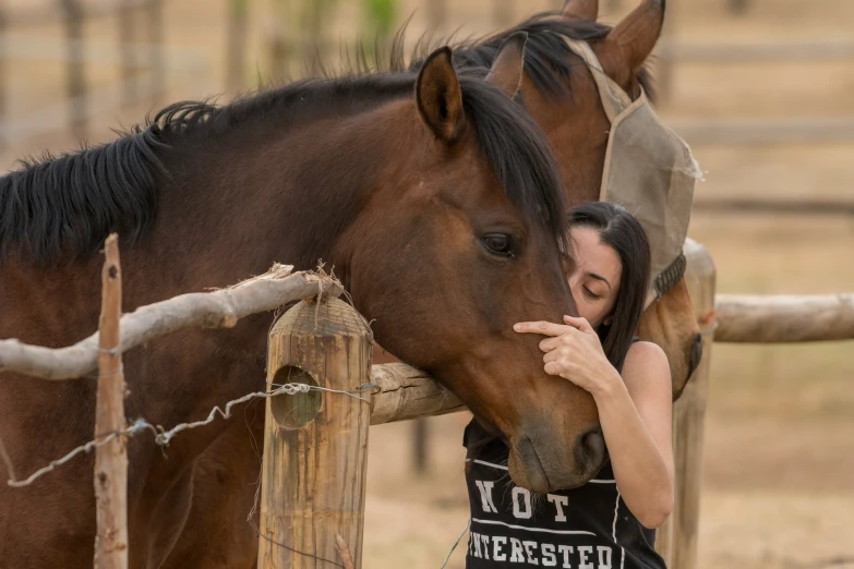 a woman with her face resting on a horse