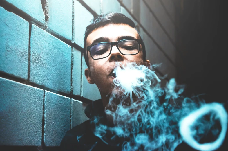 a person with glasses and smoke coming out of their mouth