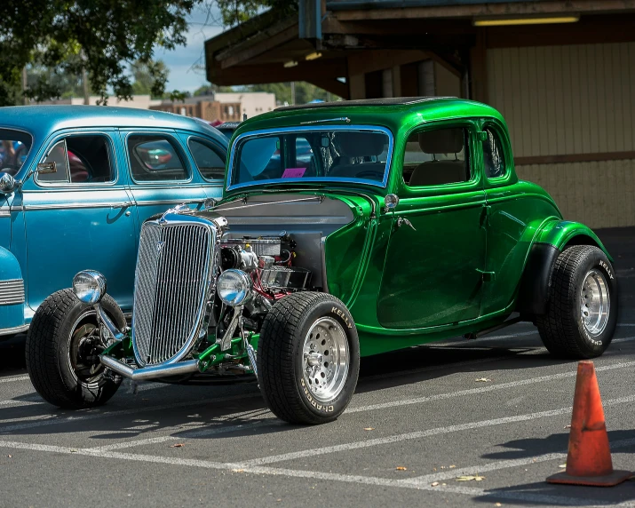 two old fashioned cars parked in a parking lot