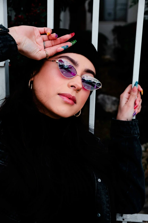 a woman in sunglasses wearing jewelry and a jacket