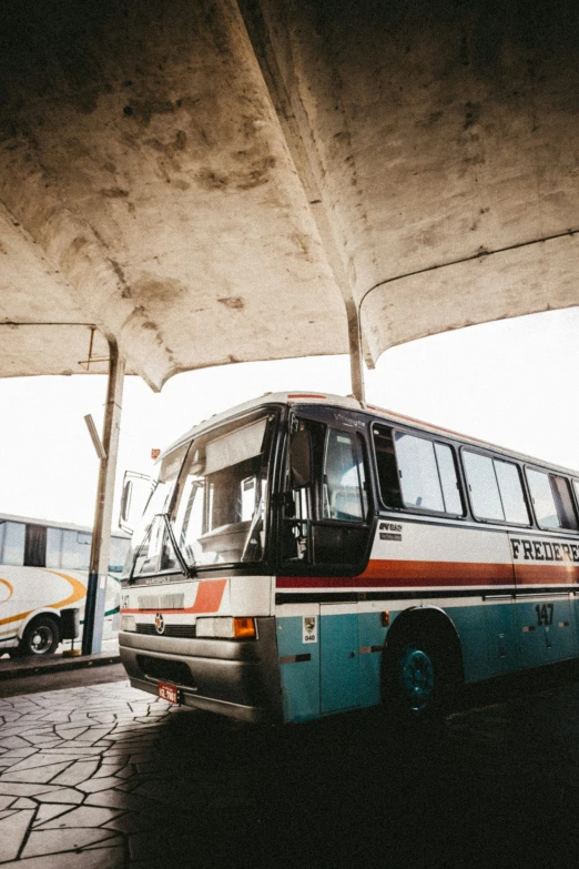 there is a bus parked under the bridge