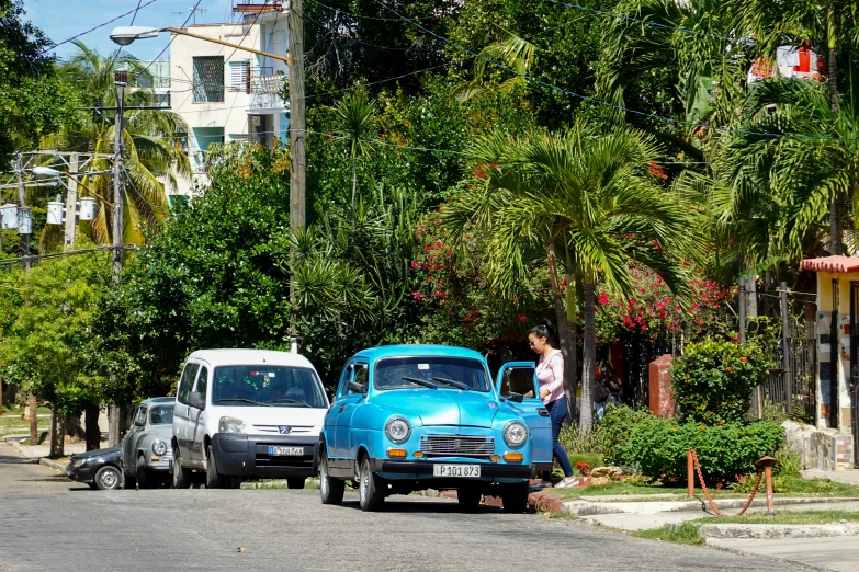 two classic cars parked in front of the beach house