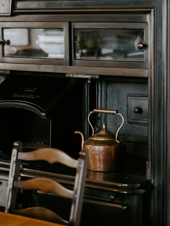 an old fashioned stove and some chairs in front of it