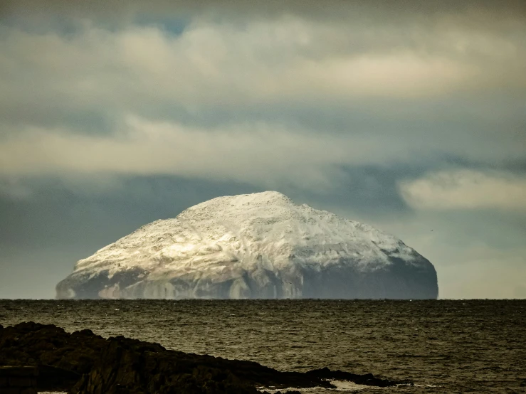 a snow covered mountain sitting on top of a rock