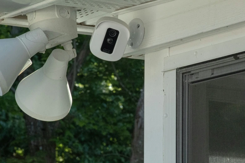 a video camera attached to a white wall near an open window