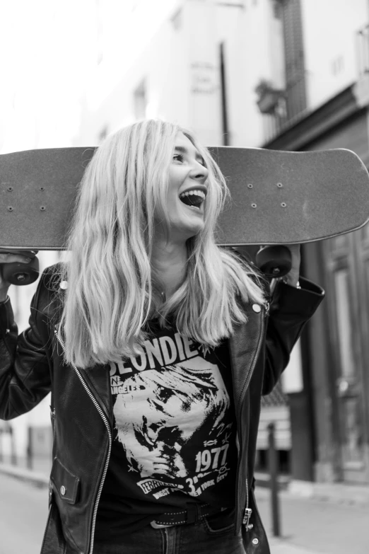 a woman holds her skateboard over her head